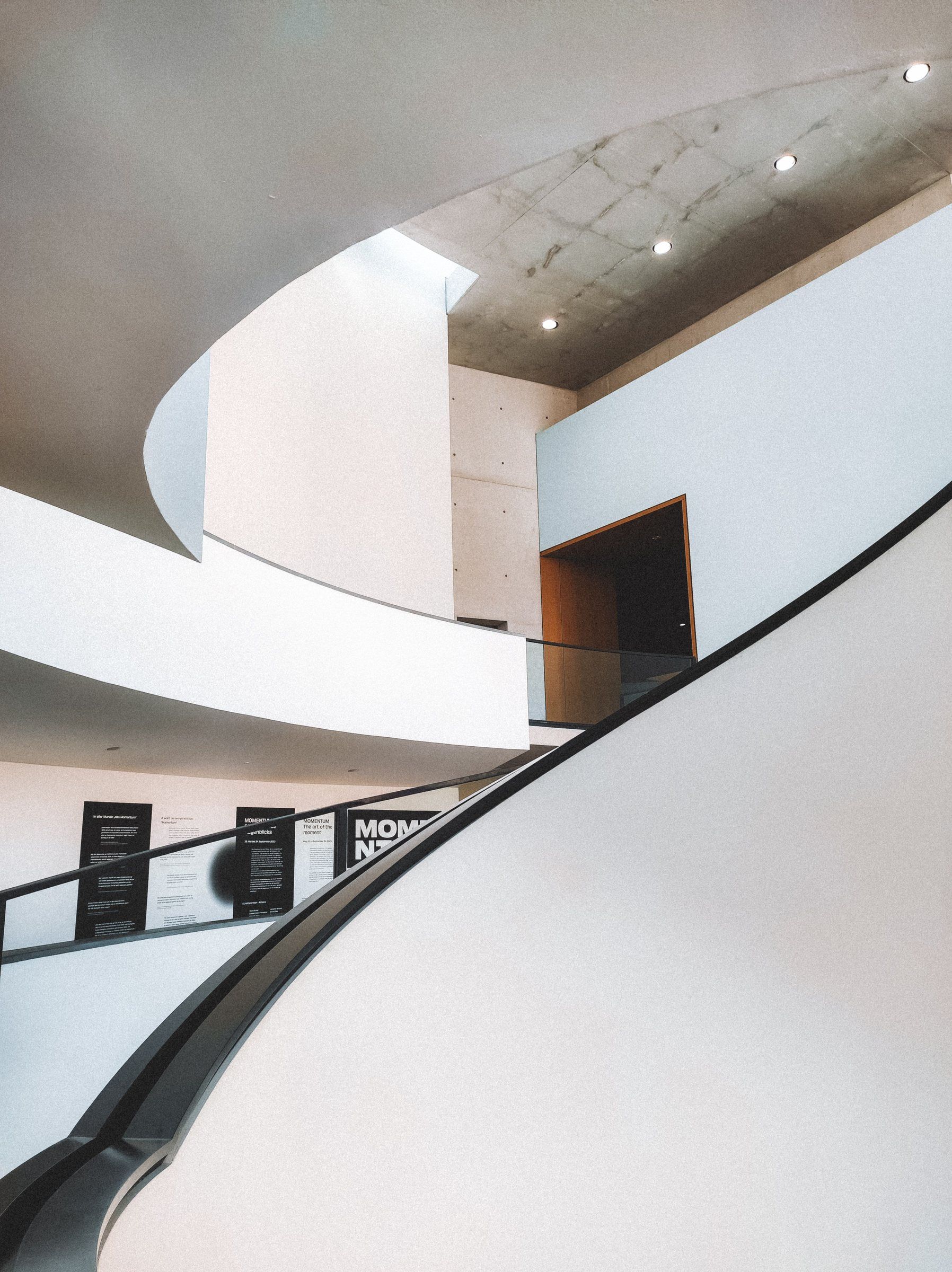 The Atrium: a sculptural white stair curving through a gallery interior