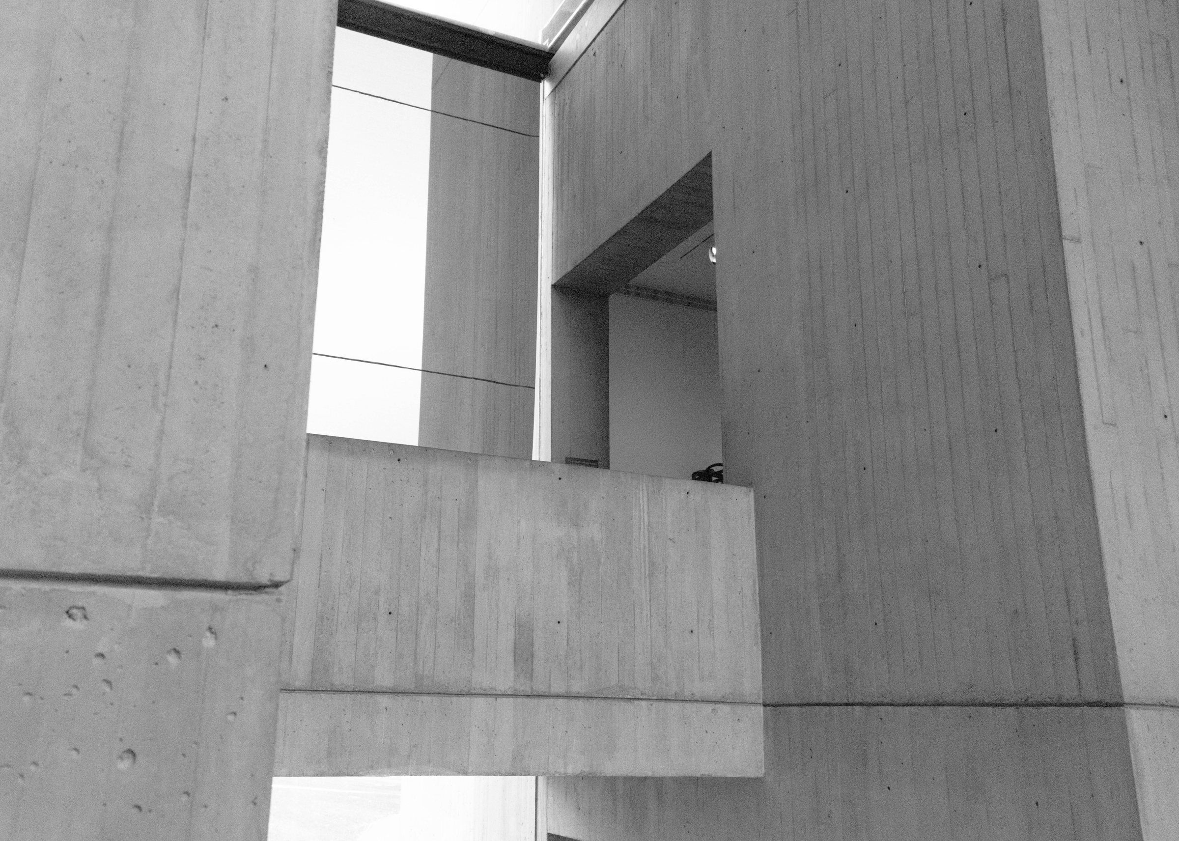Monolith House: board-marked concrete volumes and a recessed balcony